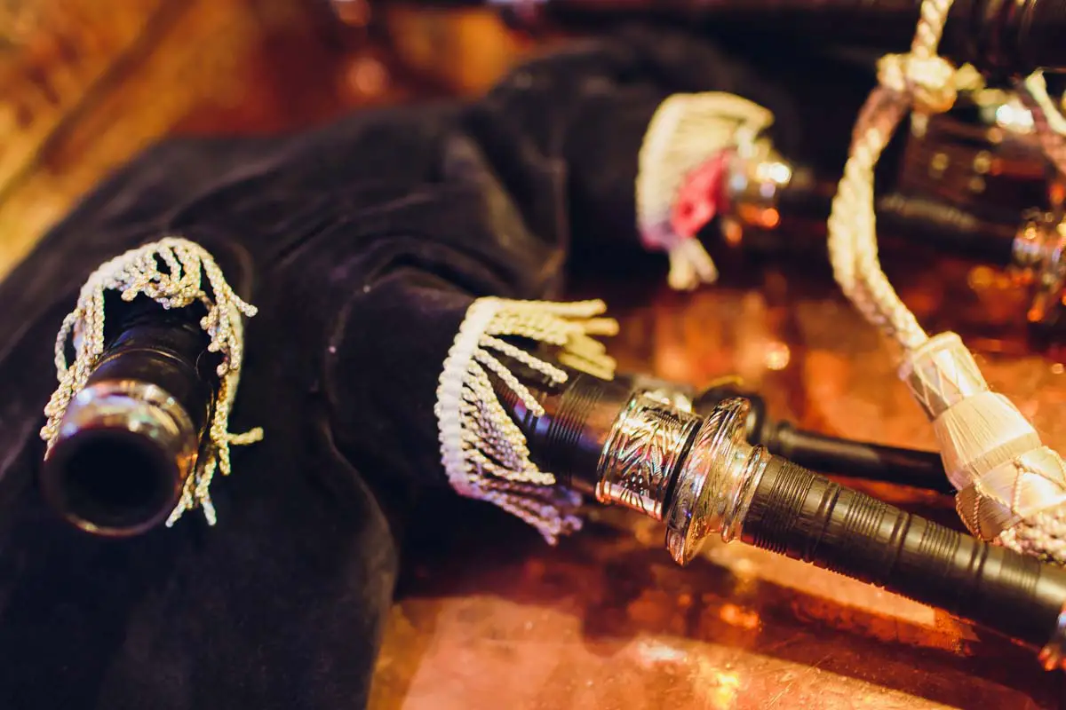 Traditional Irish uilleann pipes bagpipes laid out on a wooden table close-up