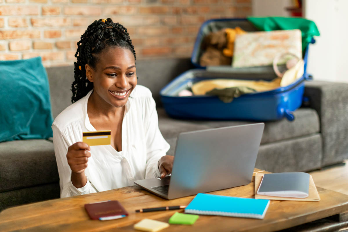 Woman books vacation with a credit card while travel planning at home