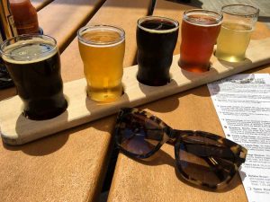 Kate Spade sunglasses and a craft beer flight on a table at Bell's Eccentric Cafe in Kalamazoo, Michigan