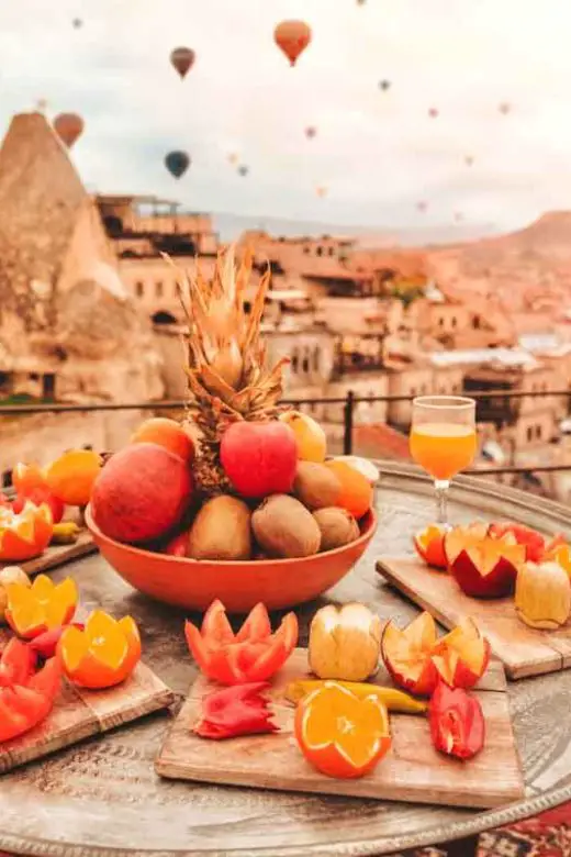 Breakfast in Cappadocia, Türkiye, as colorful hot air balloons fly over the fair chimney's of this popular Turkish travel destination