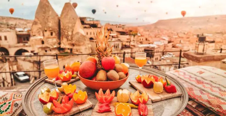 Breakfast in Cappadocia, Türkiye, as colorful hot air balloons fly over the fair chimney's of this popular Turkish travel destination