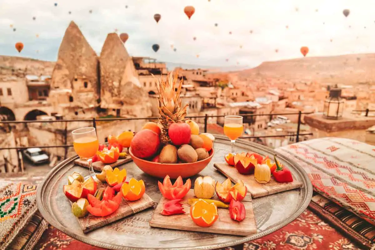 Breakfast in Cappadocia, Türkiye, as colorful hot air balloons fly over the fair chimney's of this popular Turkish travel destination