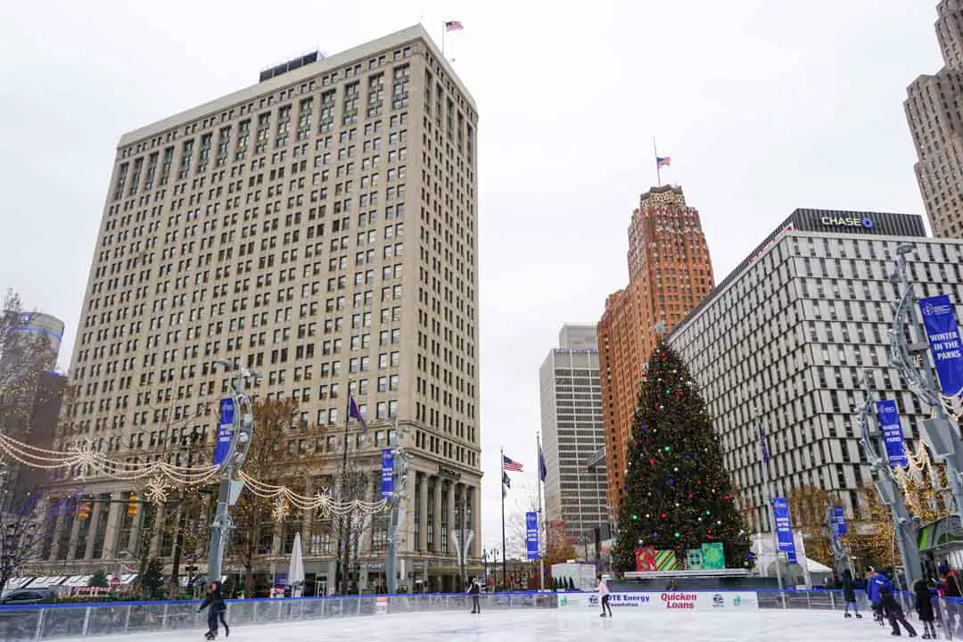 The outdoor ice skating rink at Campus Martius Park in Downtown Detroit, Michigan, with the city's Christmas tree and holiday decorations in the distance