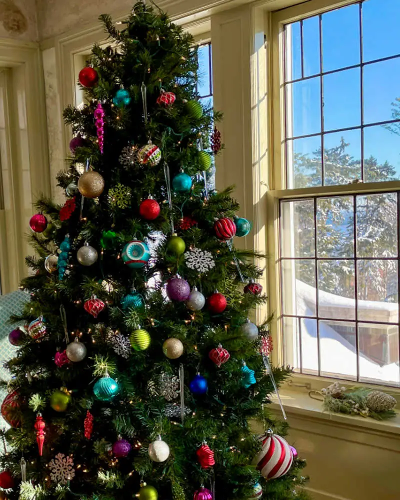 A Christmas tree is decorated with colorful ornaments in the Glensheen Mansion in Duluth, Minnesota, USA, during the Christmas holiday season.