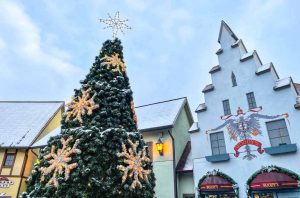 A Christmas tree is adorned with snowflake lights and a dusting of snow at the River Place Shops in Frankenmuth, Michigan