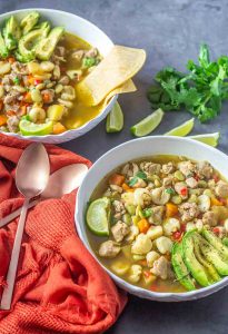 Two bowls of aguadito de pollo, a Peruvian chicken soup