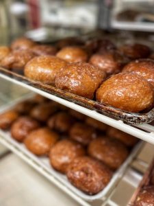 Bakery trays filled with paczki, Polish doughnuts, on Fat Tuesday (Paczki Day) at Bartz Bakery in Dearborn, Michigan, USA