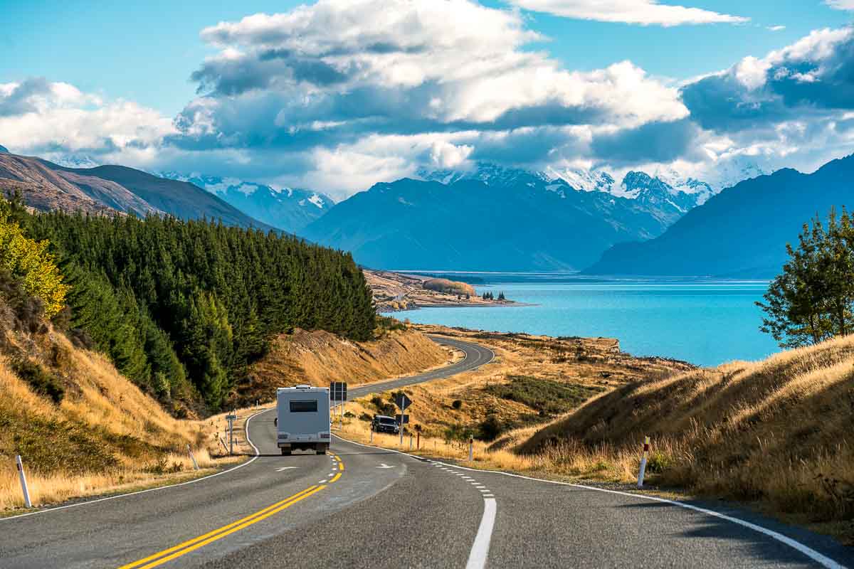 Road trip of Mt. Cook over a winding road with motorhome driving on a sunny day at Peter's Lookout in New Zealand
