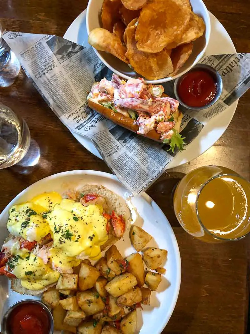 Lobster roll with chips, lobster Eggs Benedict with home fries, and a gose beer for brunch at Little Tap House in Portland, Maine