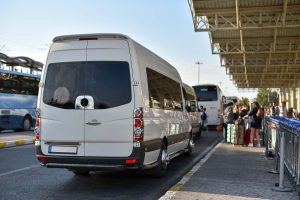 Airport shuttle service minibuses wait for passengers outside the terminal