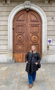 Female traveler in front of a decorative door in Milan